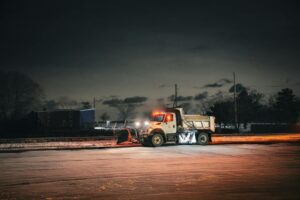 nighttime snow plow clearing urban street scene