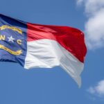 north carolina flag on a pole under blue sky