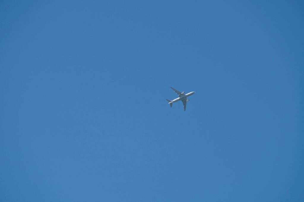 commercial airplane flying in blue sky