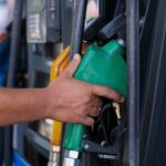 a person s hand holding a gas pump