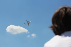 airplane soaring in clear blue sky with observer