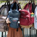 colorful backpacks hanging on hooks outdoors