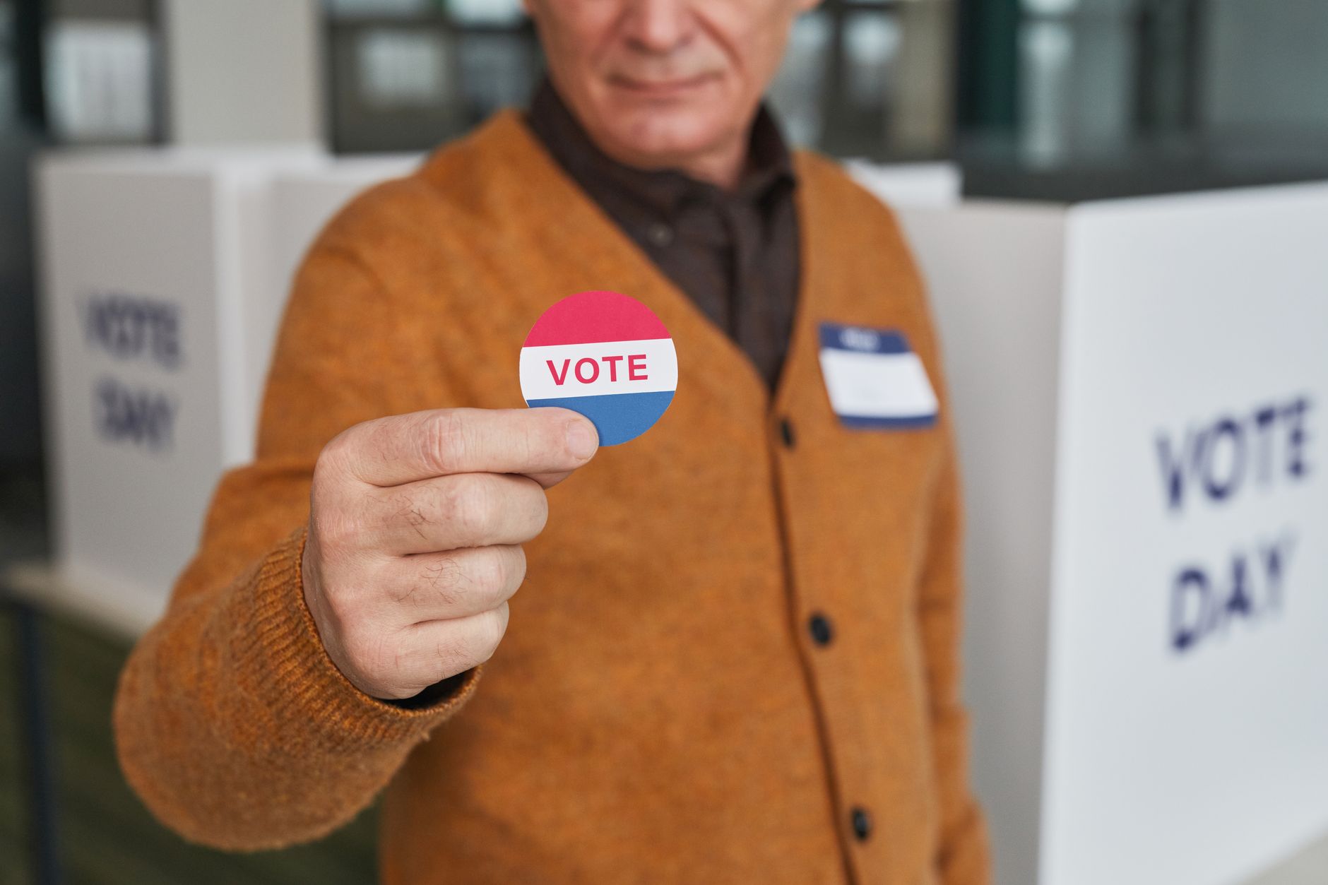 a person holding a vote badge