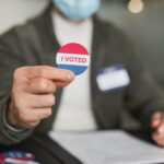 a person holding a badge with i voted